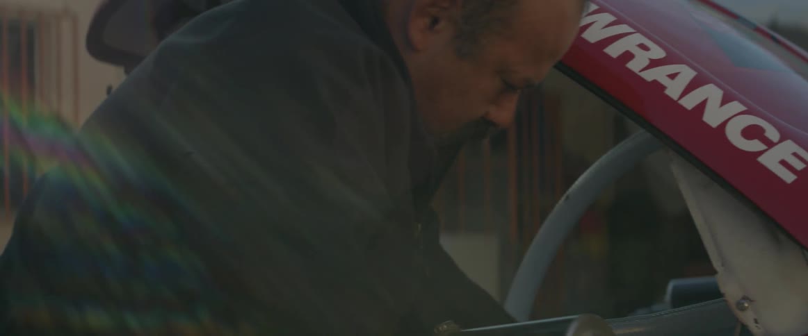 A man is working on an off-road race car