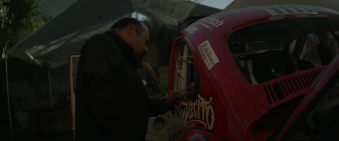 Man coughing before looking into his race car in a garage