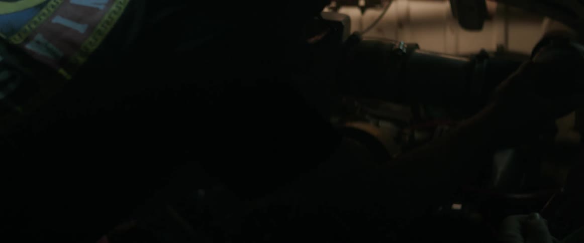 A man is working on a vehicle engine