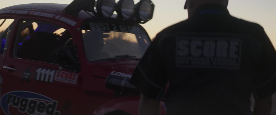 A man back his off-road race car off a ramp