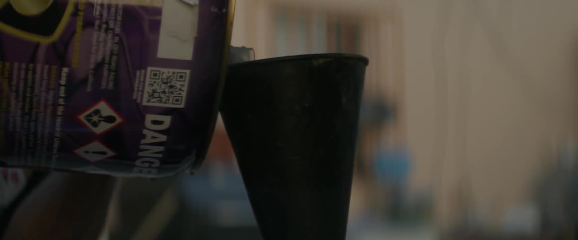 A person pours fuel through a funnel