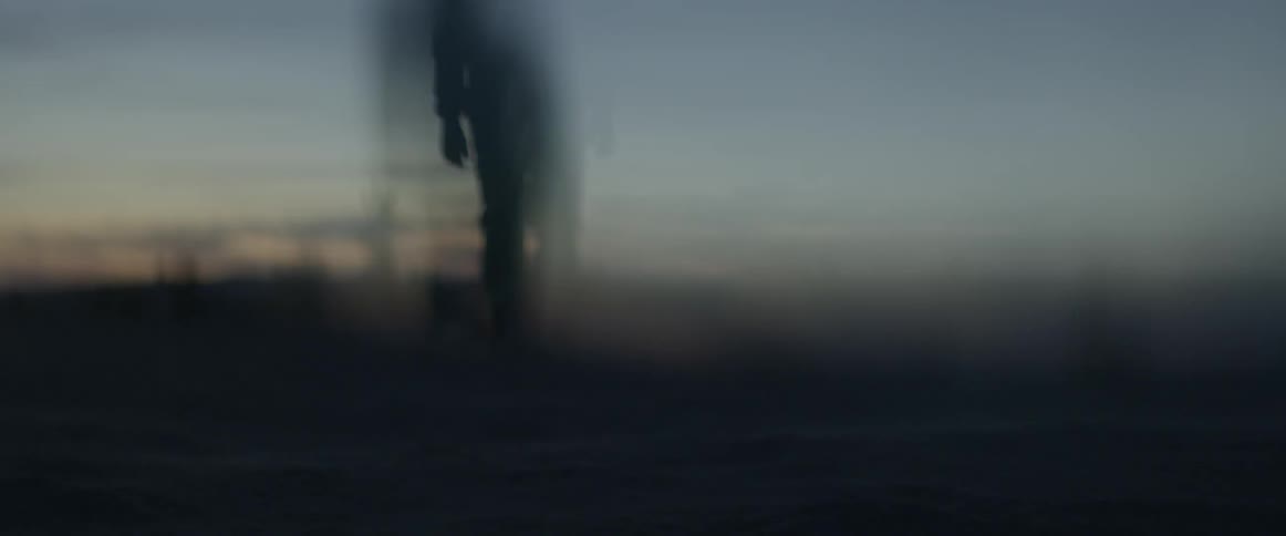 A person is walking out into the dawn sky
