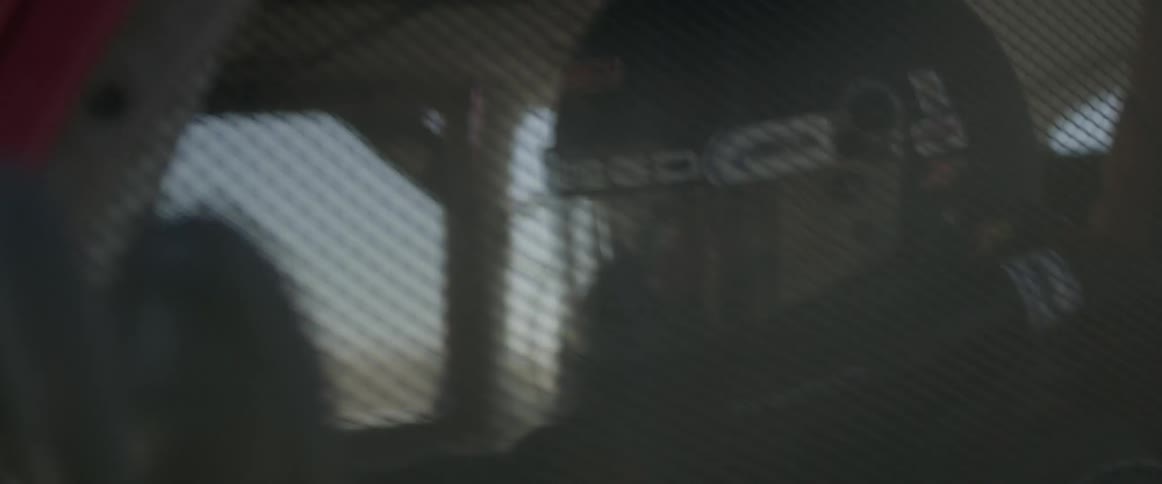A man drives a race car while wearing a helmet