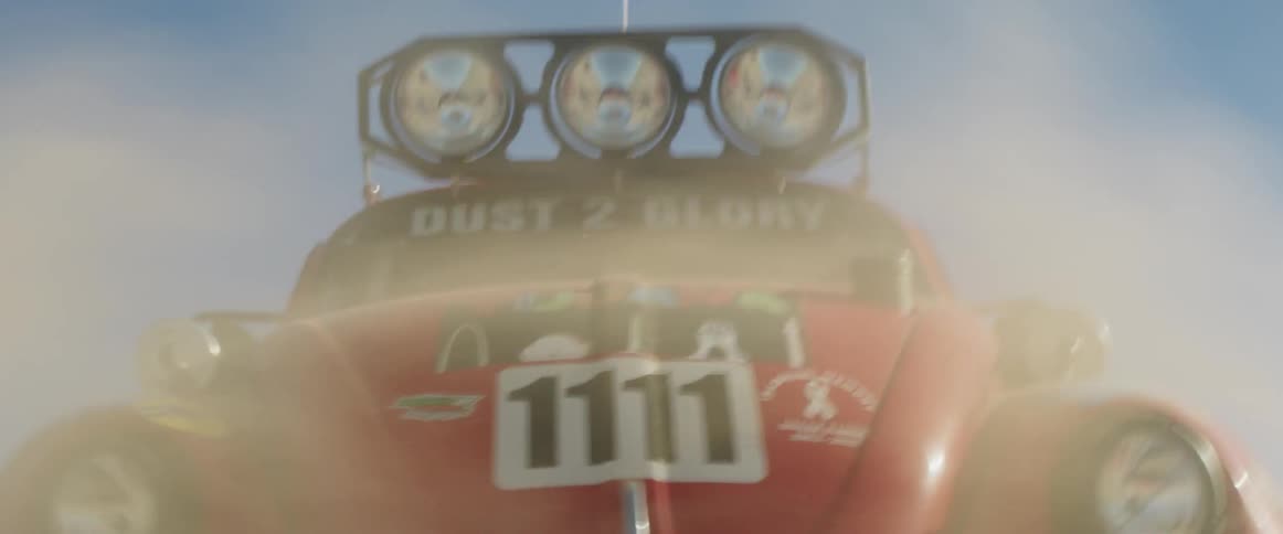 A rally car drives through the desert at high speed