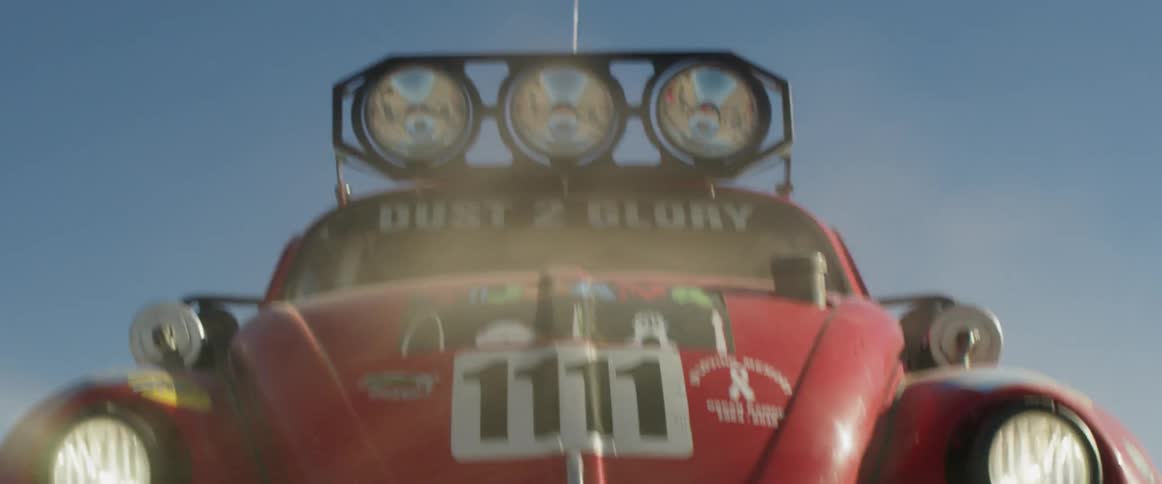 A rally car drives through the desert