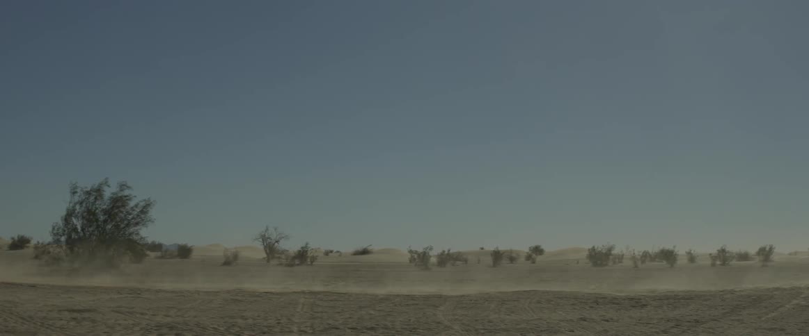 A rally car drives through the desert