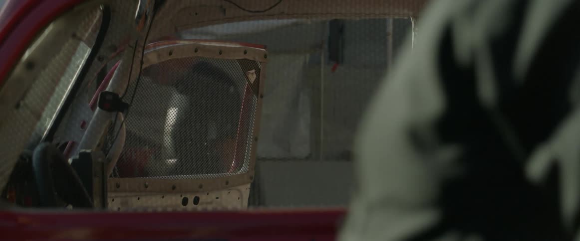 A man walks by the open door of a vehicle