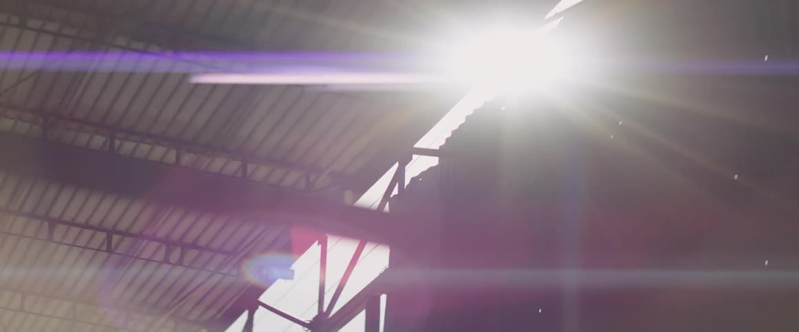 The sun shines over the top of a building and the sidewalk covering