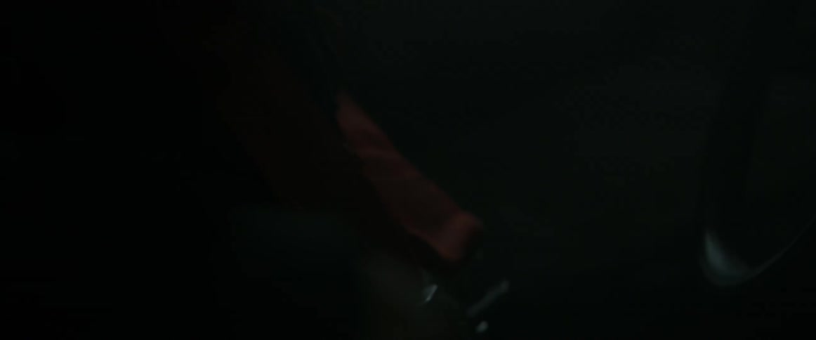 A race car driver checks his seat belt