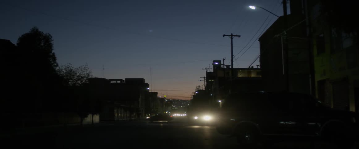 Cars travel down a city street at night
