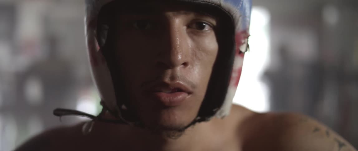 A man in a boxing helmet stares at something