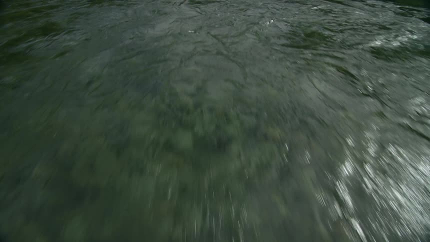 View of the surface of water with rocks underneath
