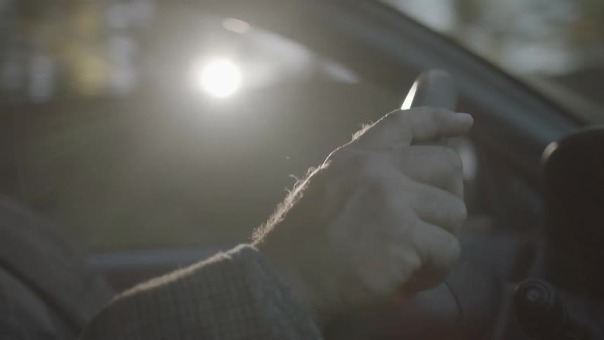 A man drives a car on a sunny day
