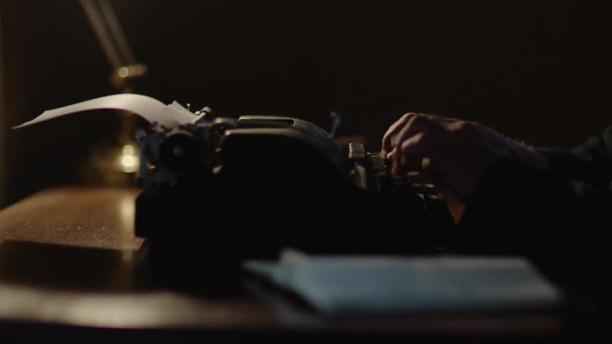 A person is using a typewriter sat on a desk