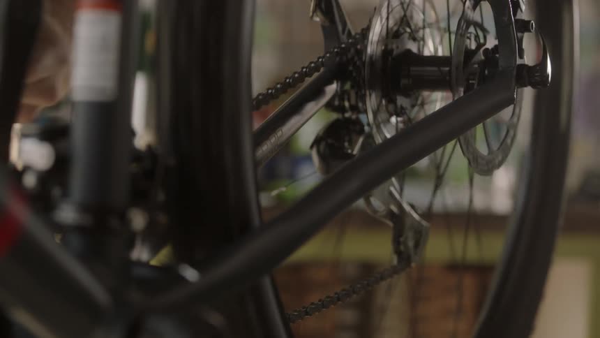 A man turns the pedals on a bicycle he is working on