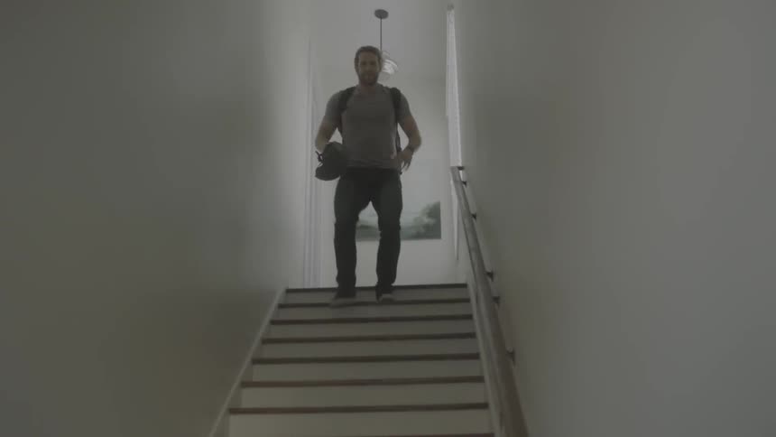 Man wearing a backpack runs down the stairs