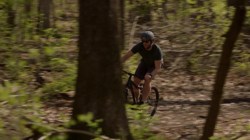A man rides a mountain bike on a forest trail