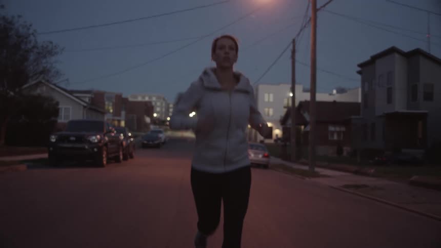 A woman jogs down a street