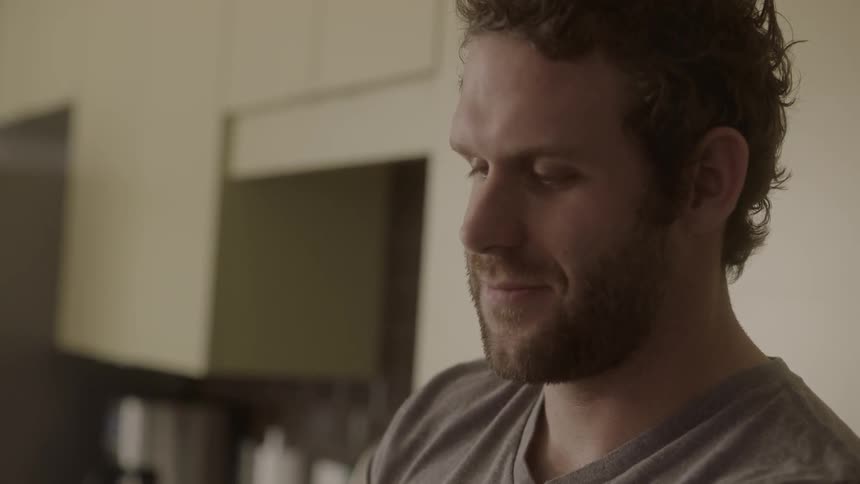 A smiling man looks at his phone