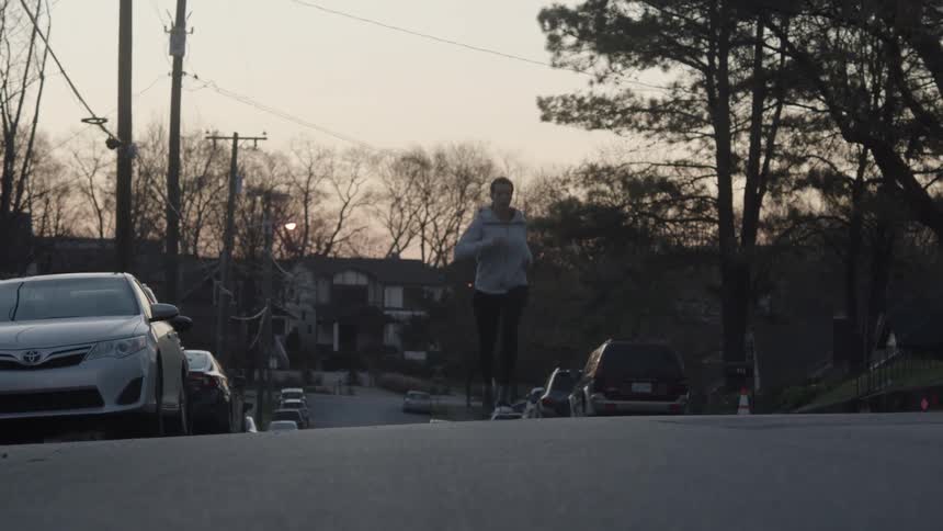 A woman jogs down a road
