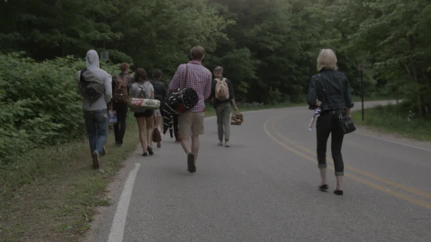 Group of people walking down a paved country road