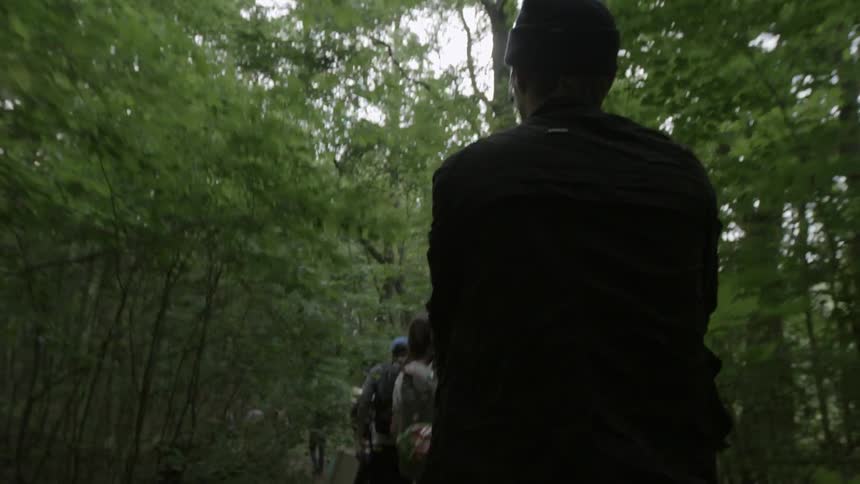 Group of people walk through the forest