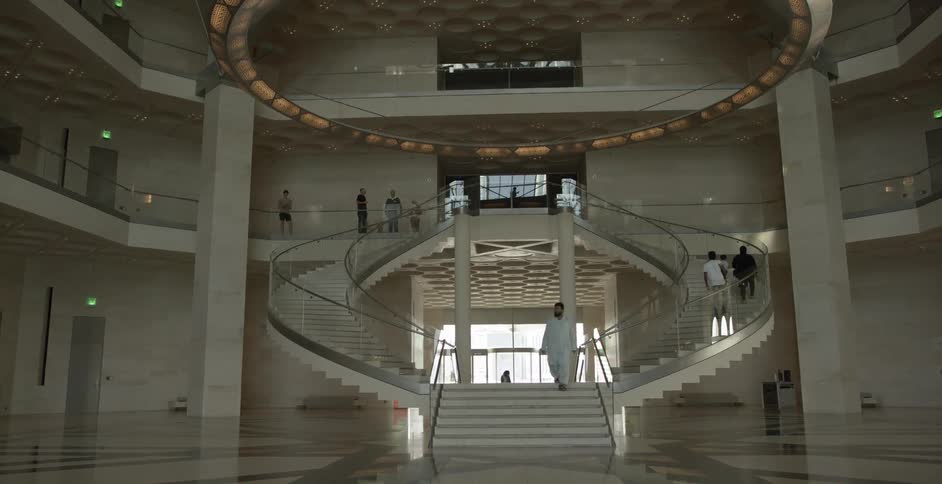 People walk on a staircase in a museum