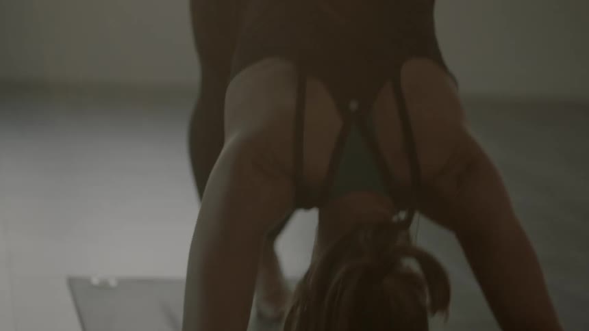Woman bent over while on a yoga mat