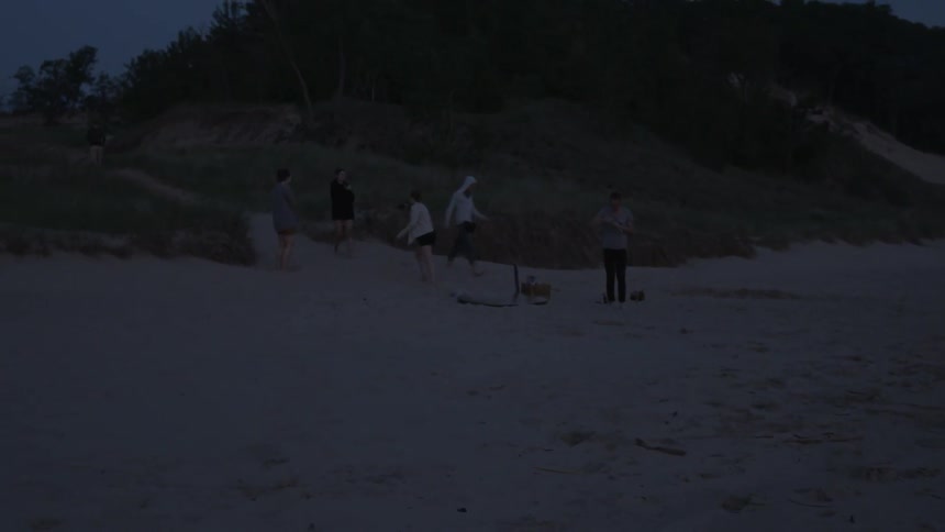 A group of friends gather on the beach