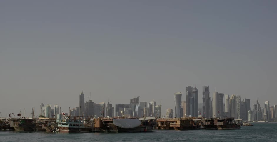 Boats float in front of city skyscrapers