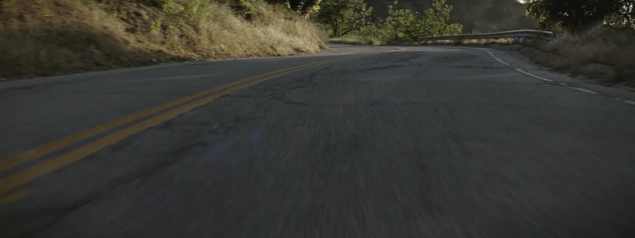 A vehicle travels on a windy mountain road