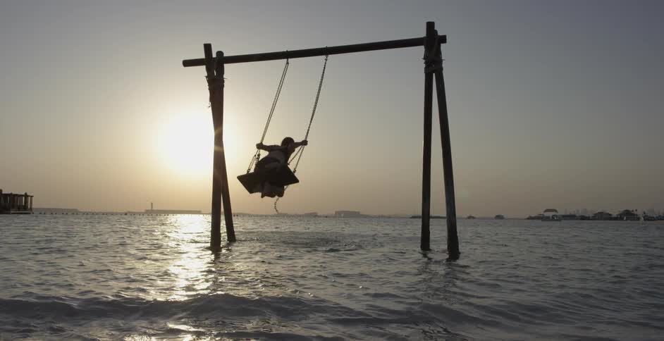 A girl swings in a body of water