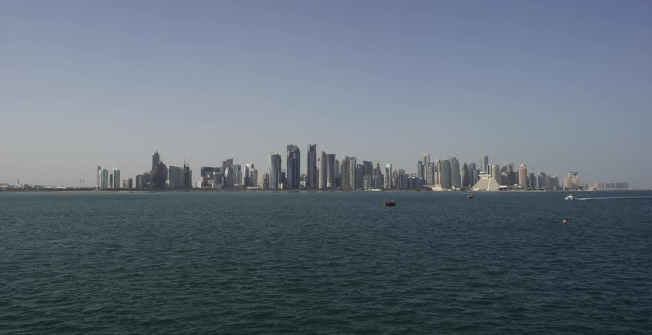 A large body of water ripples in front of a cityscape with skyscrapers