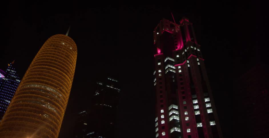 Colored lights illuminate city high rises at night