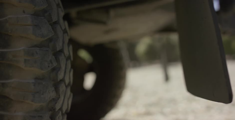 The mud flaps of a jeep blow in the wind