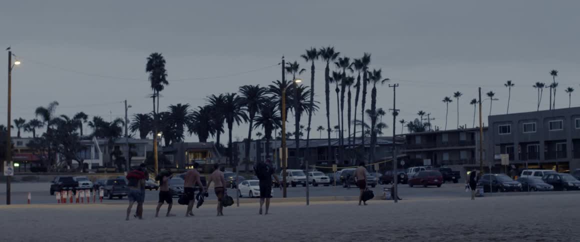 Group of people walking towards a parking lot towards some buildings