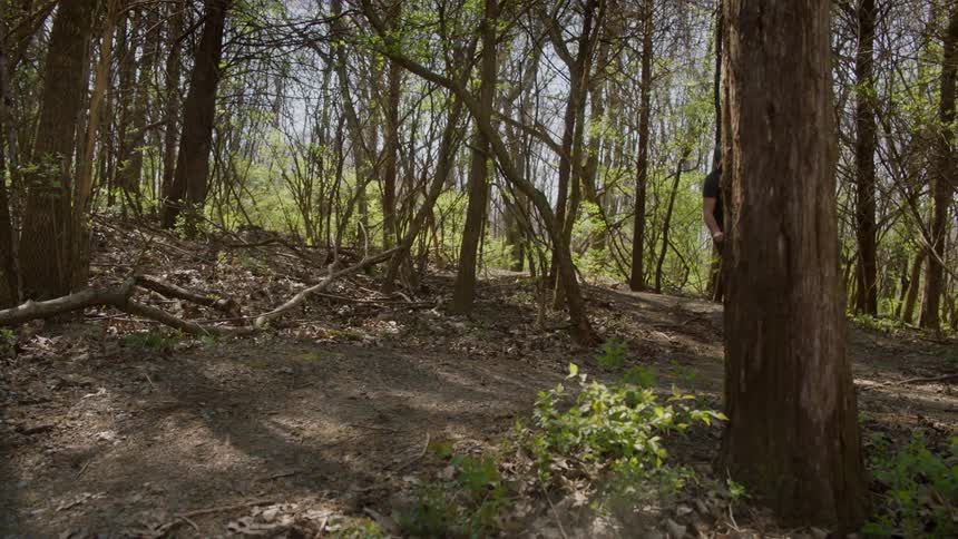 A man is riding an off-road bicycle on a dirt path in a natural setting