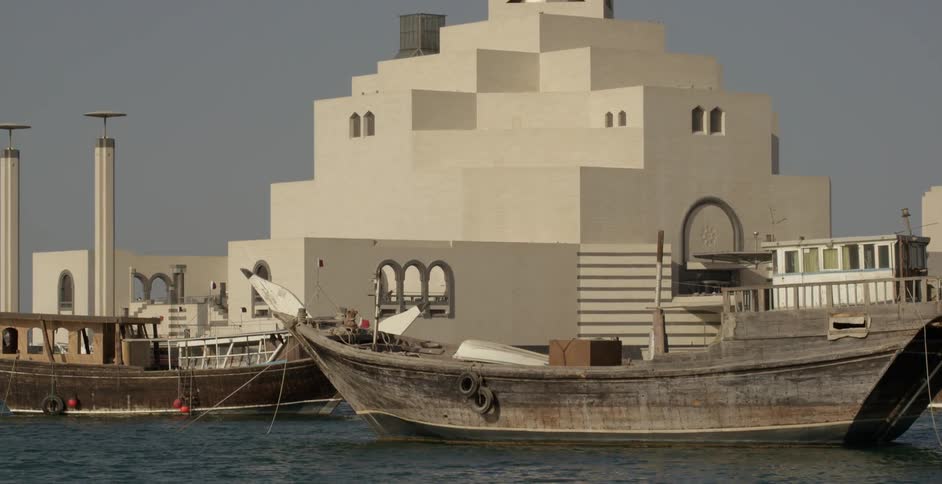 Boats float outside a museum on a sunny day