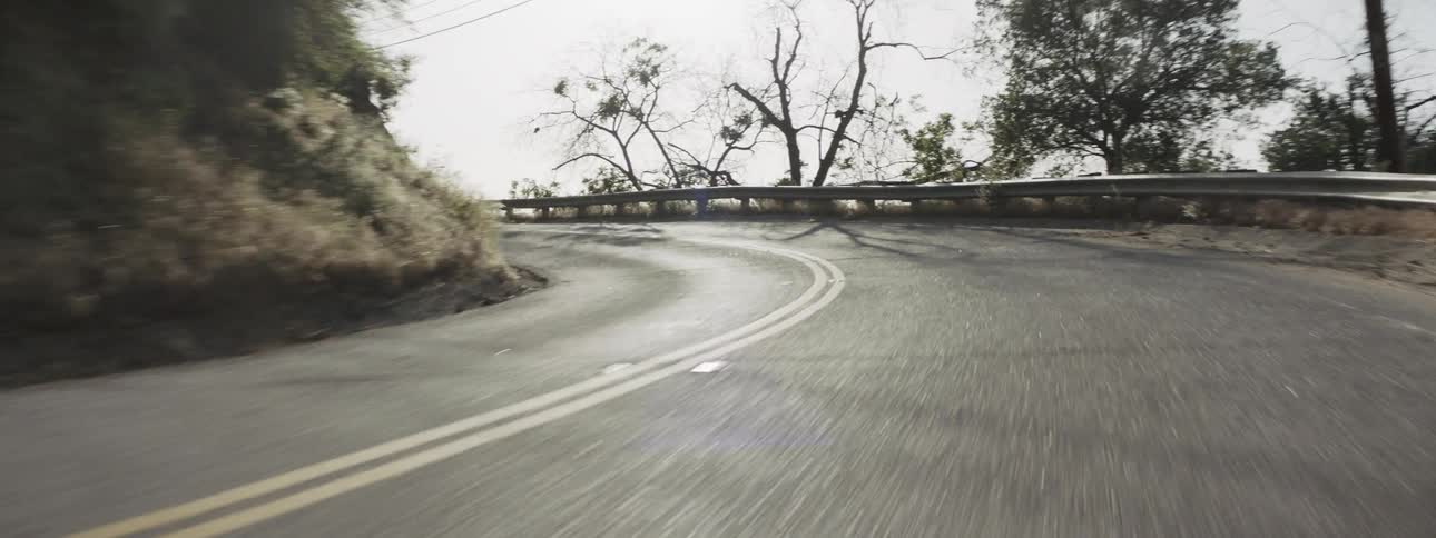 A cracked road curves near a mountain