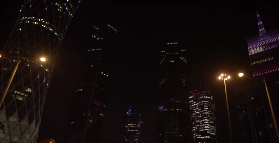 Tall lighted buildings against a night sky