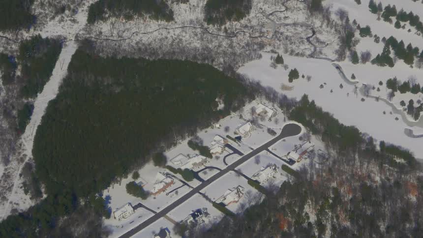 Snow and pine trees cover the ground below