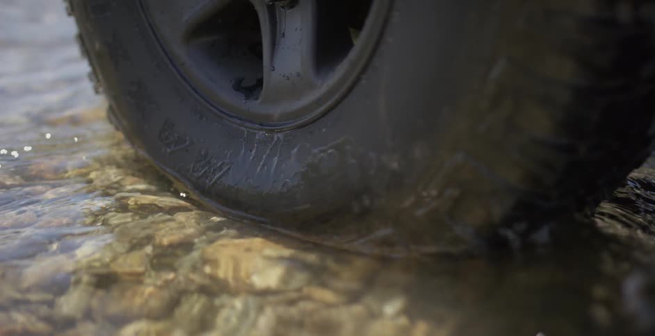 Water splashes against a car tire