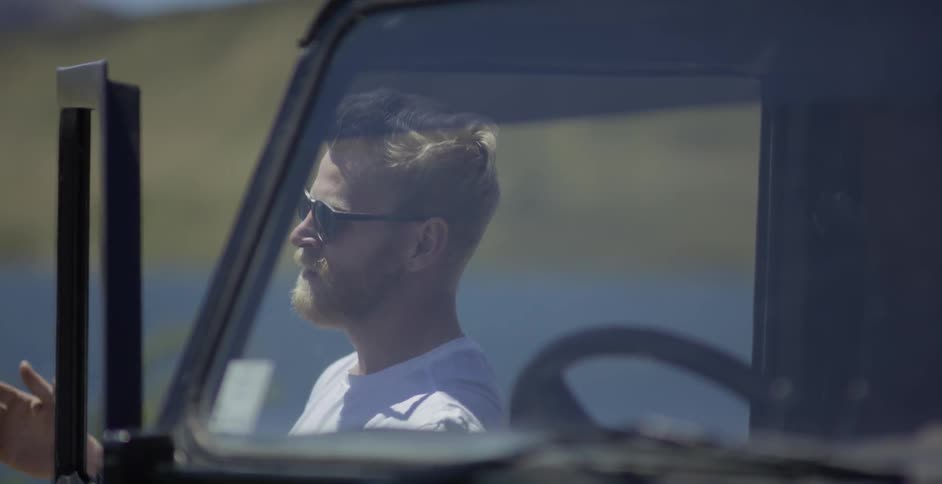 A man exits a vehicle on a sunny day