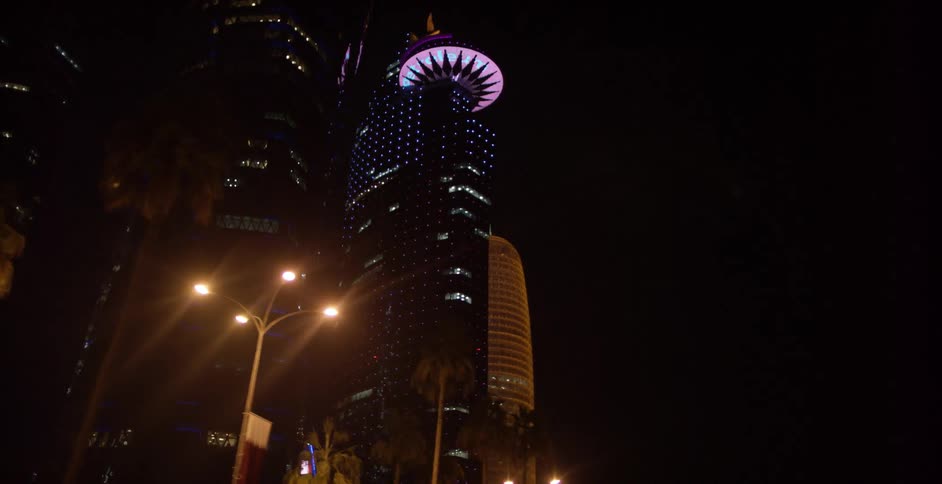 City skyscrapers are lit up against the night sky