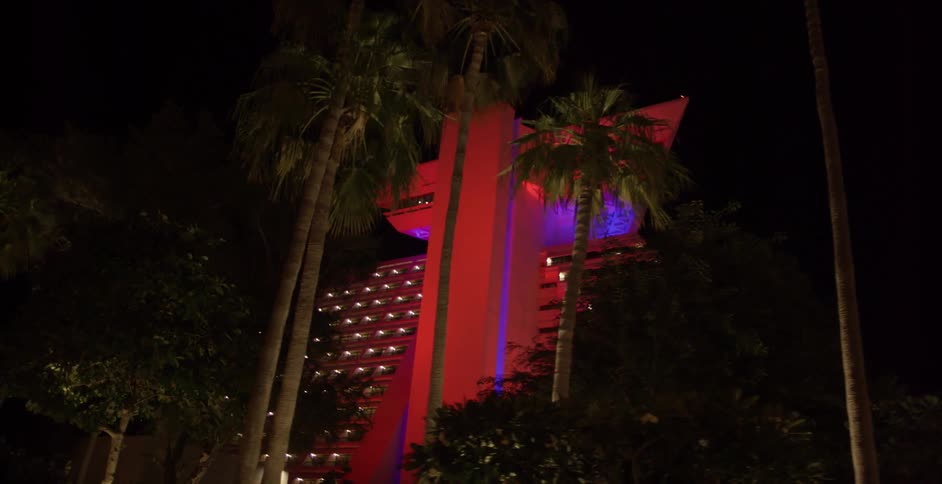 Colored lights illuminate a pyramid shaped building at night