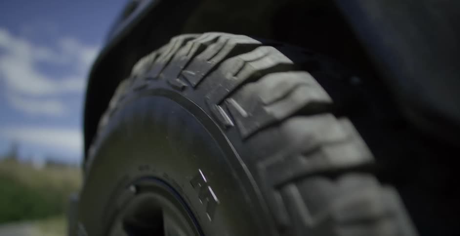 A car tire spins on a moving vehicle
