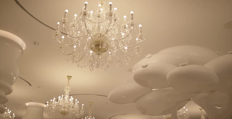 Fancy chandeliers light up a room designed in all white