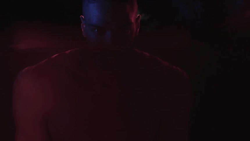 A young man stands neck deep in water at night