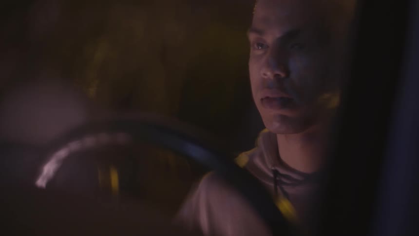 A man sits in his car in the rain