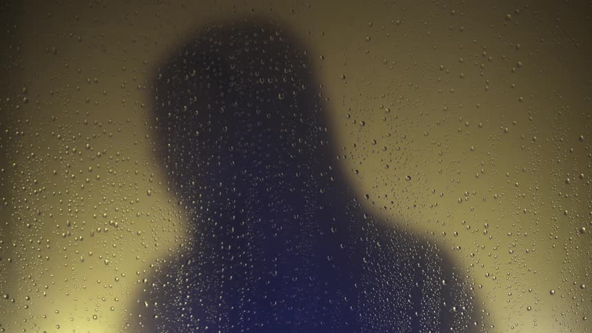Silhouette of a man putting a hood on